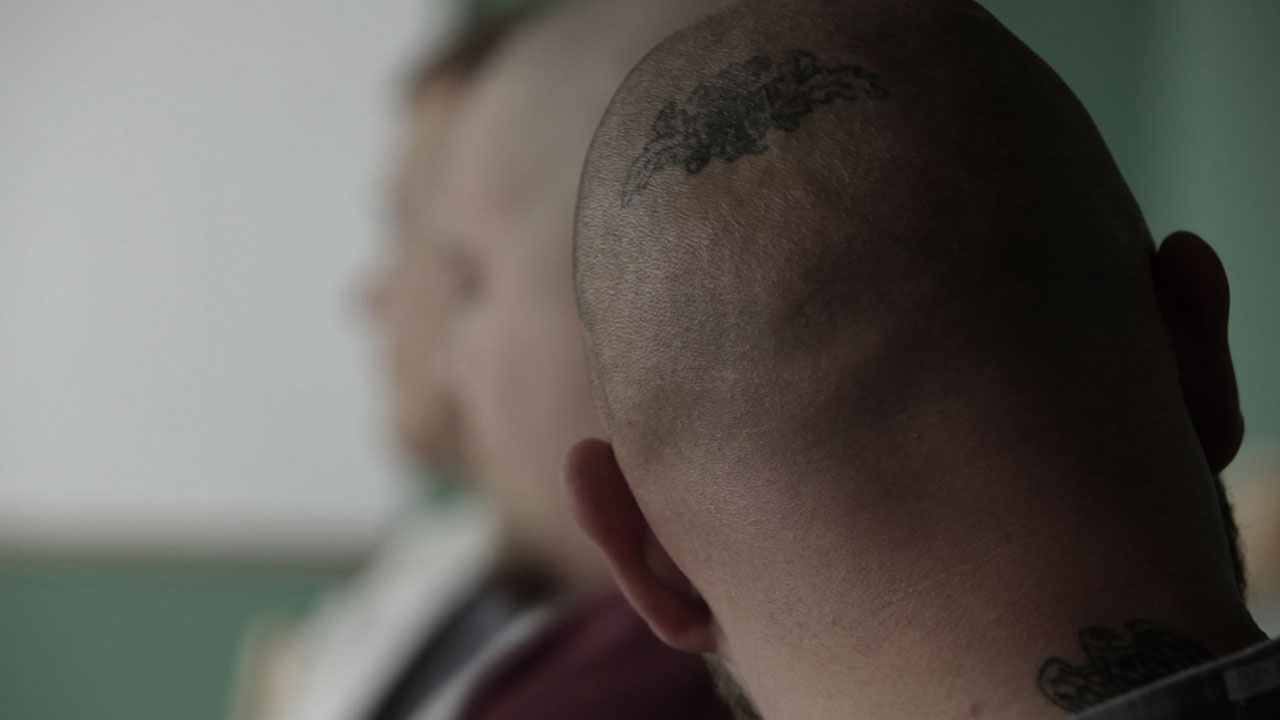 Mann mit Glatze von hinten mit Tattoo aus der rechten Szene